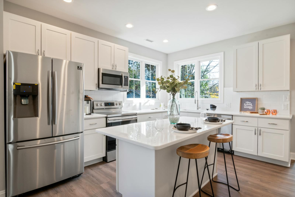 Bright and spacious modern kitchen featuring white cabinets and stainless steel. Atlanta Granite Pros
