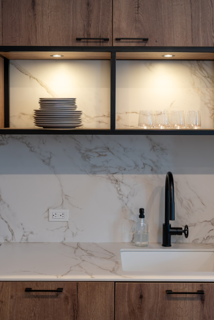 Modern kitchen with sink, faucet, and stacked plates featuring a full height backsplash with quartz counter tops. Atlanta Granite Pros